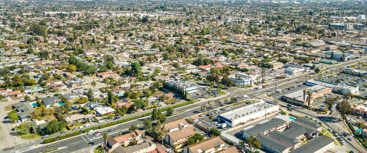 An aerial view of a densely populated urban area with numerous buildings, roads, and green spaces.