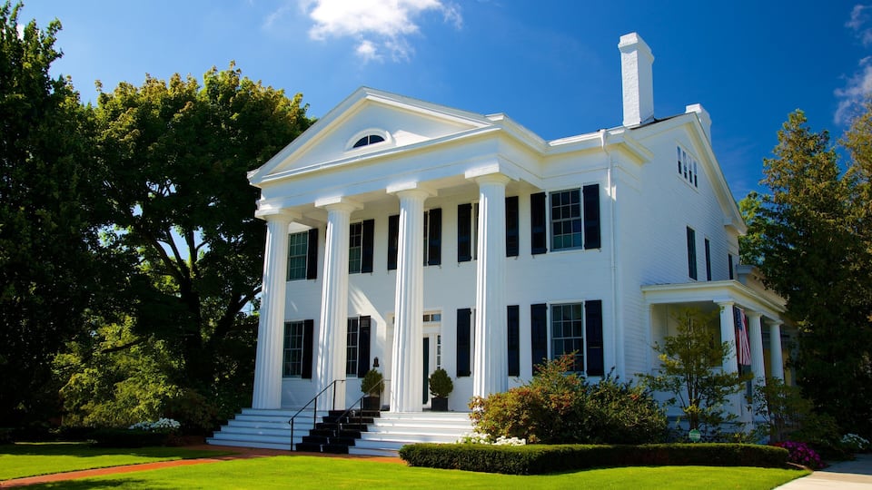 A white colonial-style house with a front porch, columns, and a chimney.