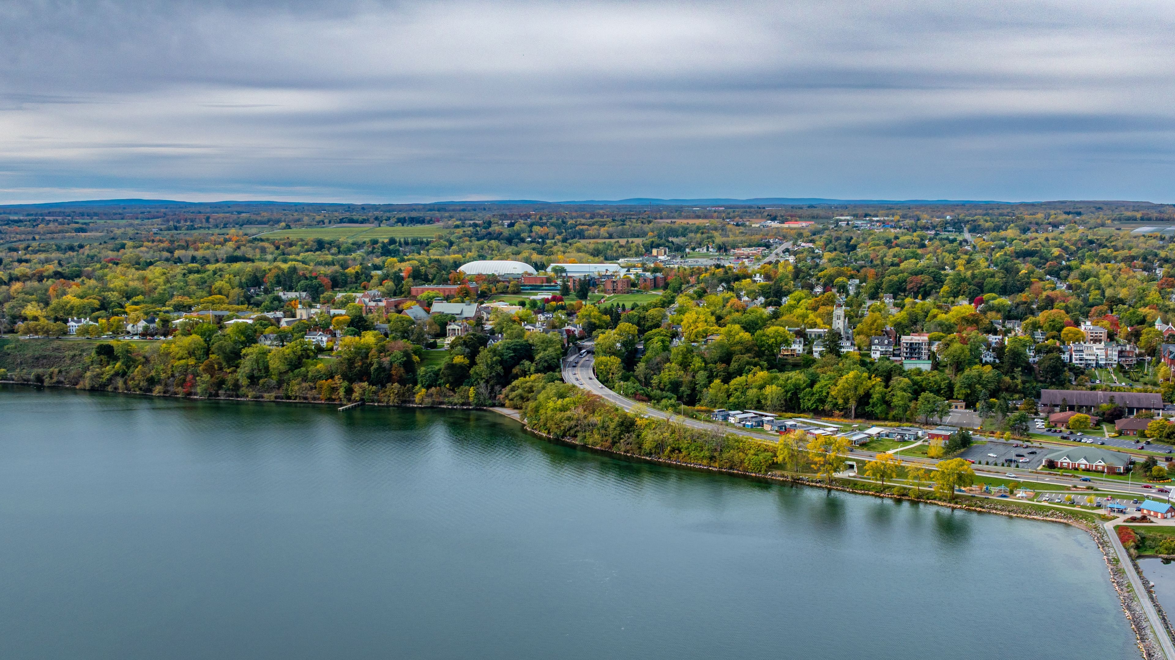 A lakeside town with autumn foliage, a prominent stadium, and a mix of residential and commercial buildings.