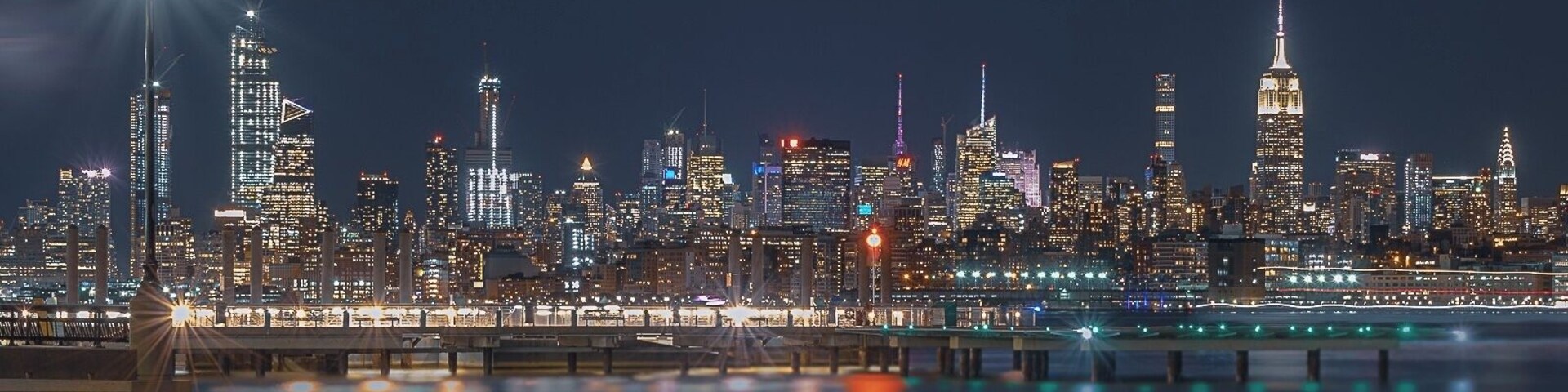 Midtown Manhattan as seen from the New Jersey’s J. Owen Grundy Park. This beautiful skyline showcases the Empire State Building and the Chrysler Building among one of the most prominent and historical architectural structures of the city.