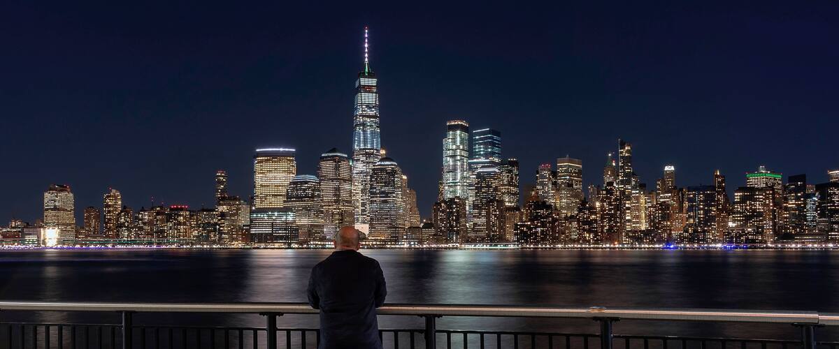 “The Long Exposure Selfie” 
This is the view of New York City’s downtown financial district as seen from Jersey City, New Jersey. The Freedom Tower stands mightily over the Hudson River where US Airways Flight 1549 had to make an emergency landing after losing both engines to bird strikes. It has popularly come to be known as “The Miracle On The Hudson”. This sight is less than half a mile from the Exchange Place Path train station. One can also reach this place via the New York Water Taxi Service. This place is truly a sight to behold and should be on everyone’s itinerary when visiting The Big Apple!