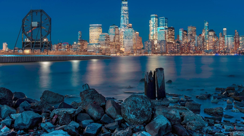 NYC from NJ. This is the view of downtown New York from the Morris Canal Park in Jersey City, NJ. The park itself is right in the heart of Jersey City about a half mile from the Path Train Station and the NYC Taxi Waterway. It’s a small patch of land in the midst of high rise apartments. While I was there, I could see it’s a popular spot among nearby residents who make it a habit to end their hectic day with their children and pets while taking in the view of the financial district as well as the Colgate clock in the foreground. It’s a peaceful and friendly neighborhood as well as I had the opportunity to strike up conversations with several locals.