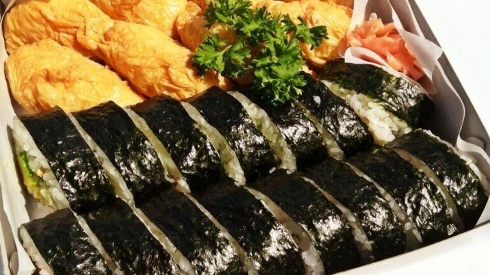 Freshly made inari and nori sushi bento unwrapped in the car