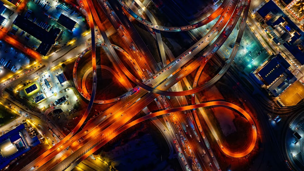 Bright illumination of roads in the downtown of Dallas, Texas, USA. Top view on the transport moving by the highways at night.