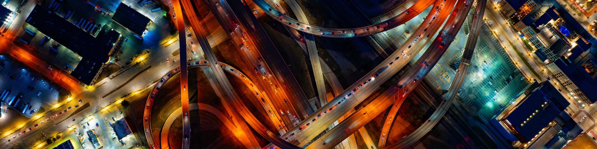 Bright illumination of roads in the downtown of Dallas, Texas, USA. Top view on the transport moving by the highways at night.