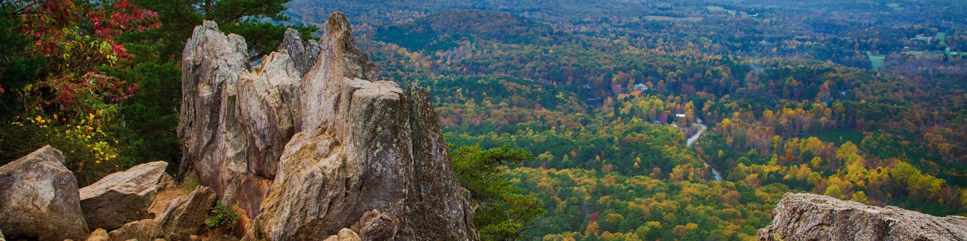Crowders Mountain State Park has a wealth of great trails which end with great views of North Carolina piedmont. The two main destinations are Crowders Mountain (2.8 mile walk from Sparrow Springs Access) or the Pinnacle or King's Pinnacle. The Pinnacle trail is a pleasant 2 miles trek uphill through rich forest. The last little bit has some rock scrambling with signs that urge carefulness. But the views are stupendous, especially with fall colors in full display. (About 45 minutes west of Charlotte, NC)