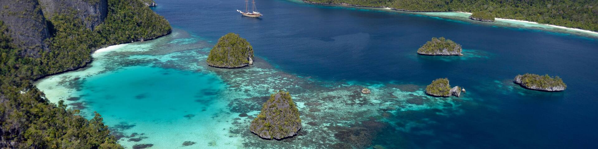 Scenic view of Wayag Islands and sailing boat Lamima Raja Ampat Indonesia
