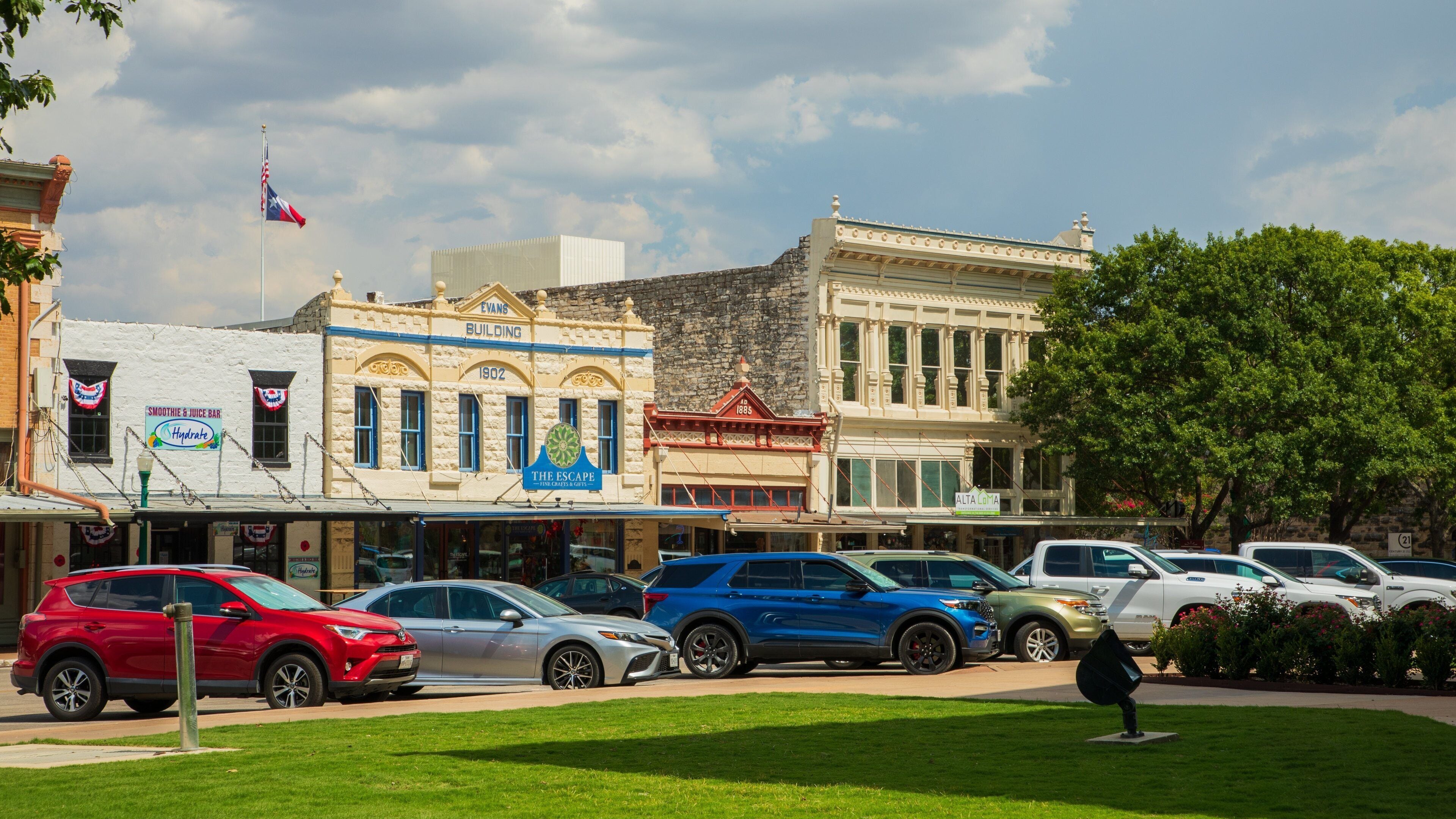 A street lined with historic buildings, including a Smoothie & Juice Bar and The Escape.