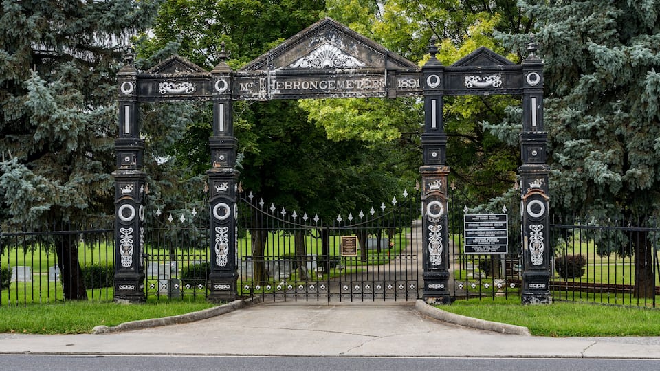 A historic gate with intricate designs and the inscription "Mt. Hebron Cemetery 1891".