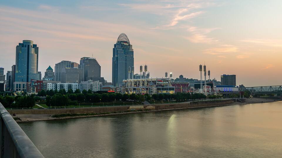 A city skyline with modern skyscrapers and a river in the foreground.