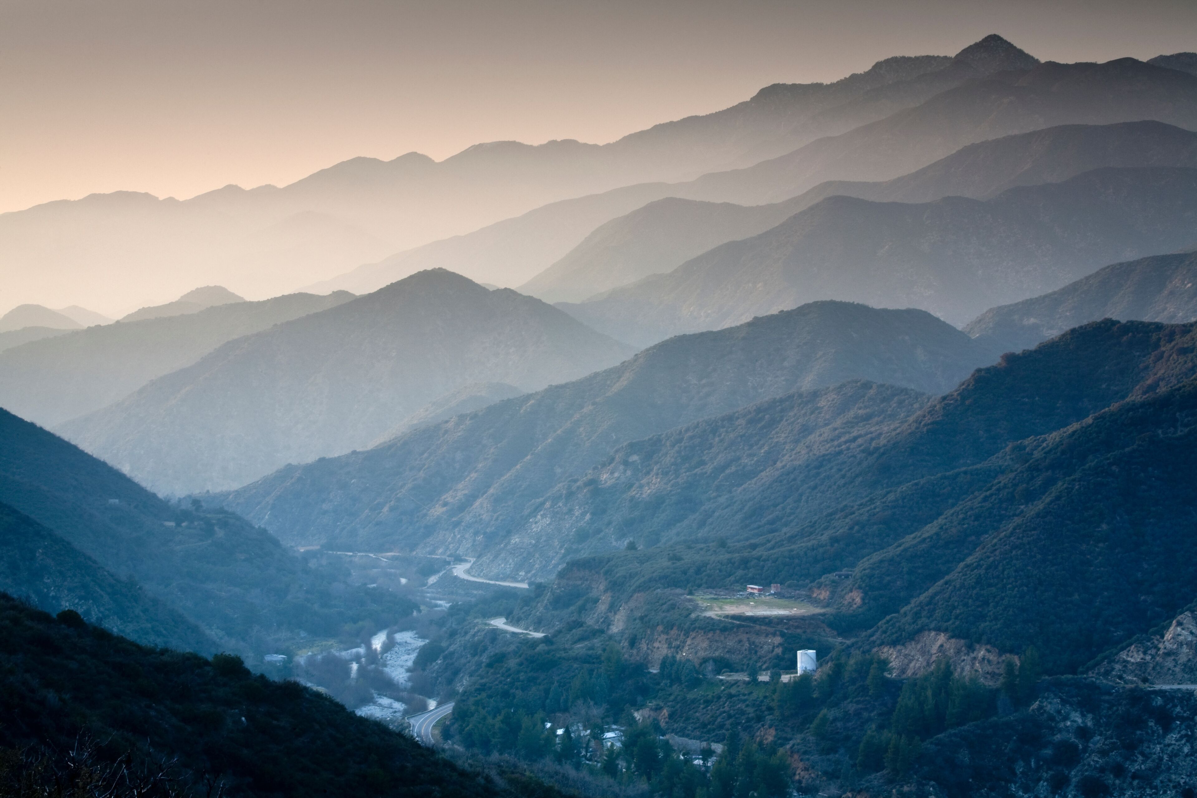 A mountainous landscape with a winding river and a small settlement.