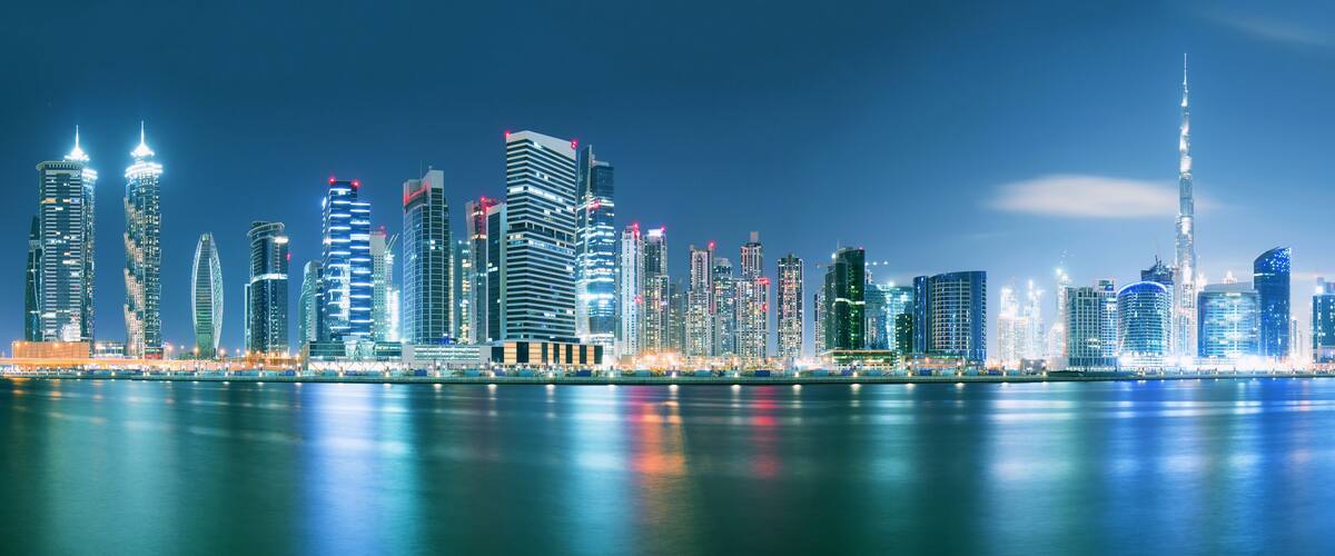 Dubai skyline after sunset with beautiful city center lights reflection and promenade around the canal, Dubai, United Arab Emirates