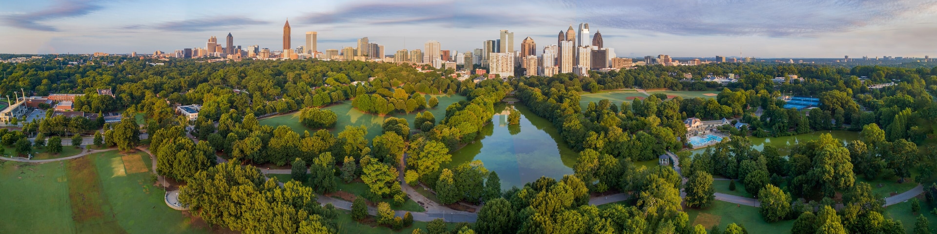 Ein Blick von oben auf eine Stadt mit einem weitläufigen Park im Vordergrund und einem Horizont aus Wolkenkratzern im Hintergrund.