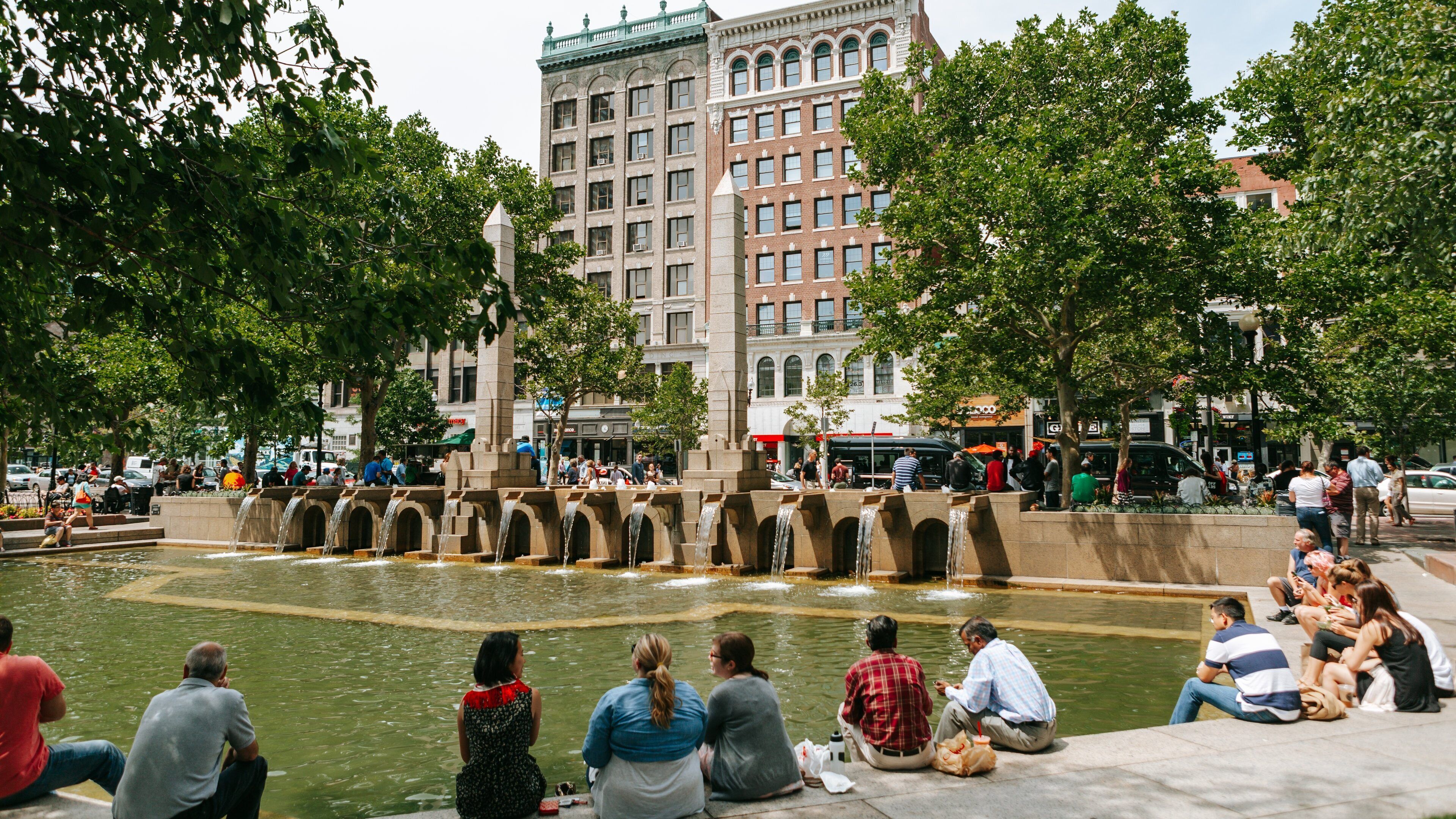 Back Bay which includes a fountain and a river or creek as well as a small group of people