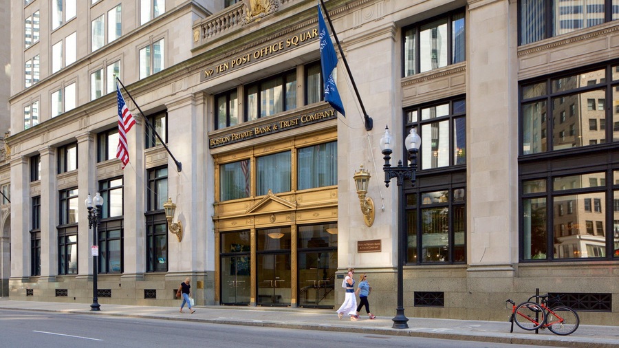 A historic building with ornate architecture, a prominent entrance, and flags.