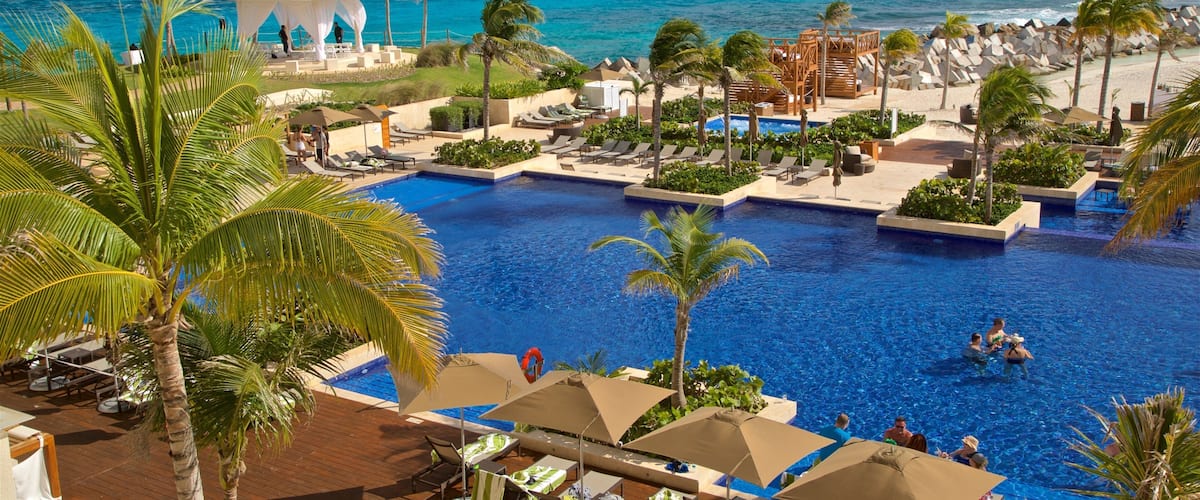 Zona dos Hotéis que inclui uma piscina, cenas tropicais e paisagens litorâneas