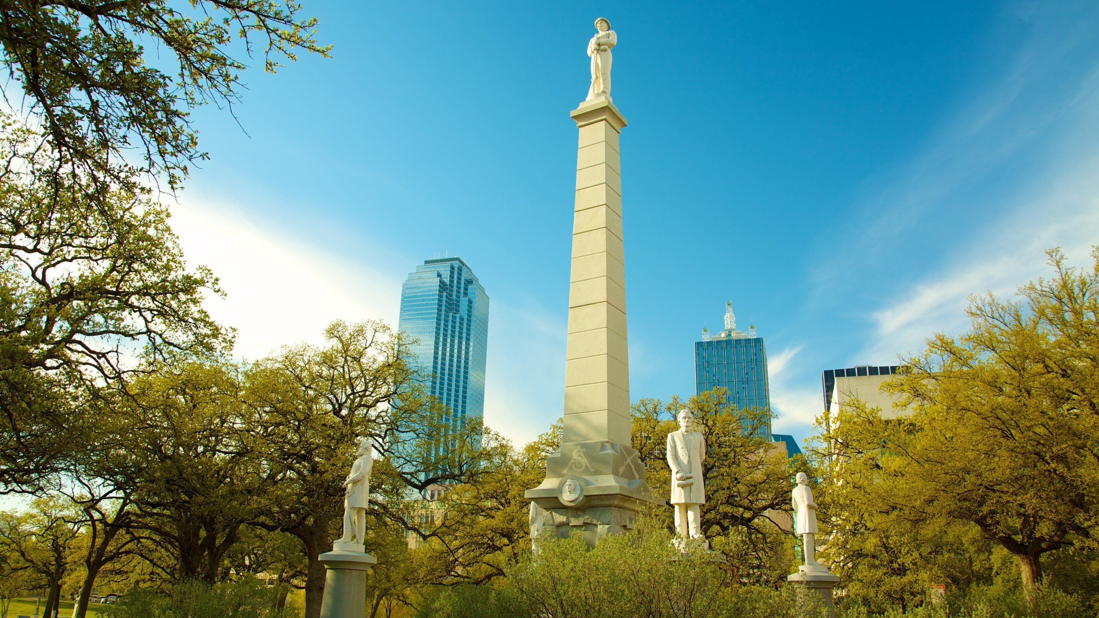Un monumento rodeado de árboles y edificios modernos.