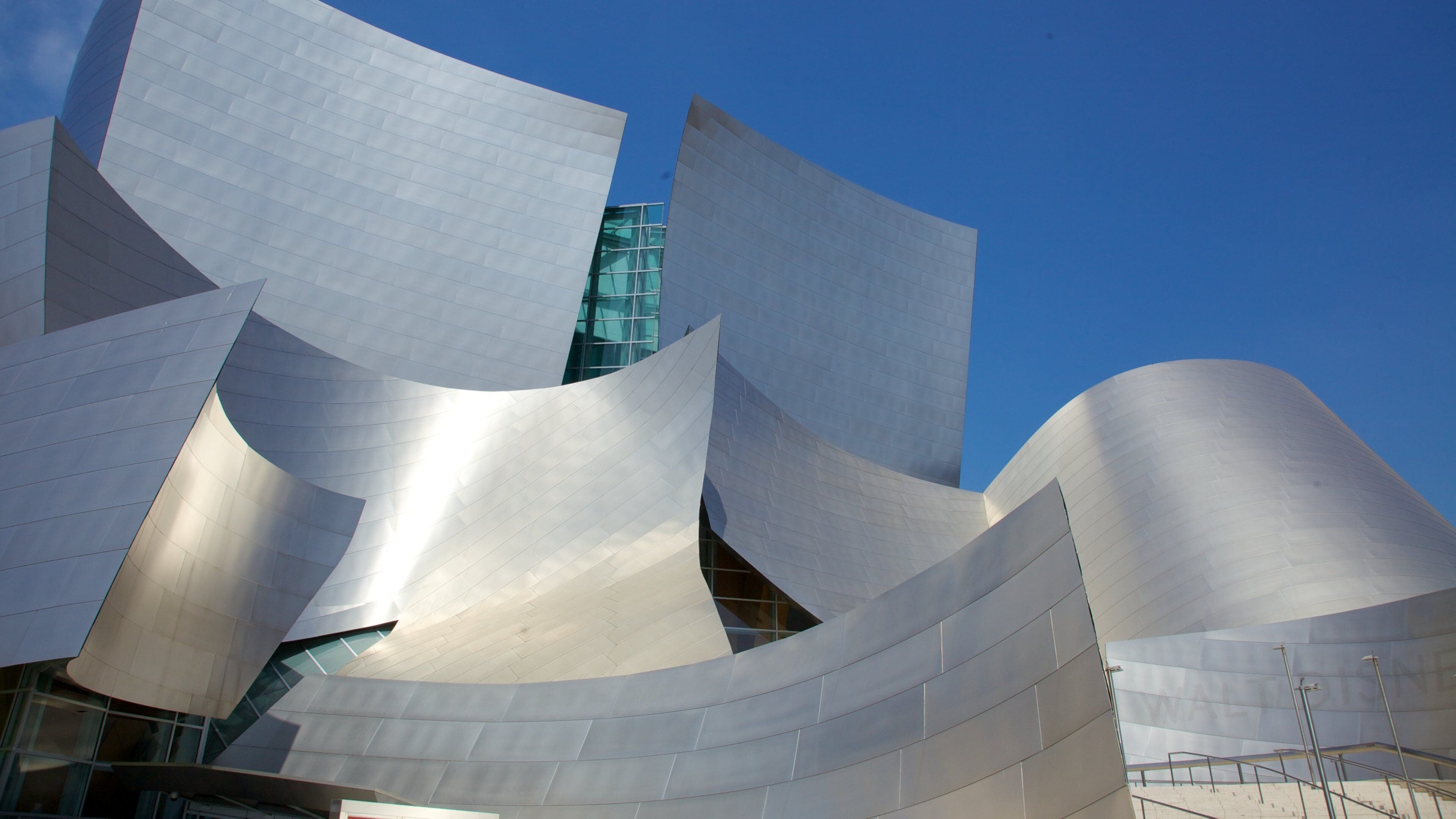 A modern architectural structure with curved metallic surfaces and glass windows.