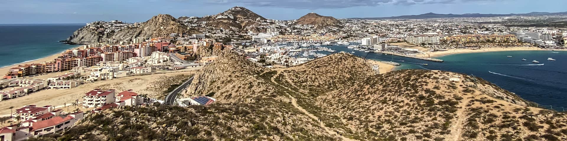 A coastal city with a prominent mountain, a marina, and a beach.