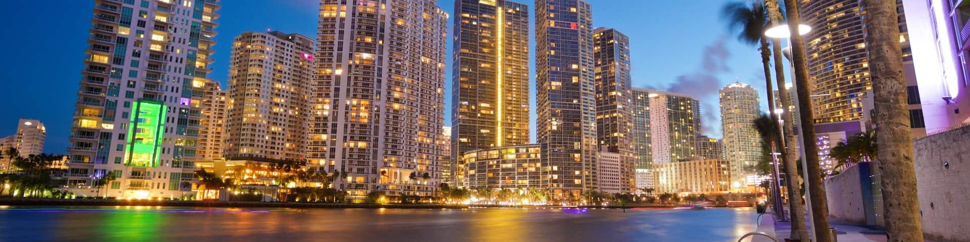 Downtown Miami which includes night scenes, a city and a river or creek