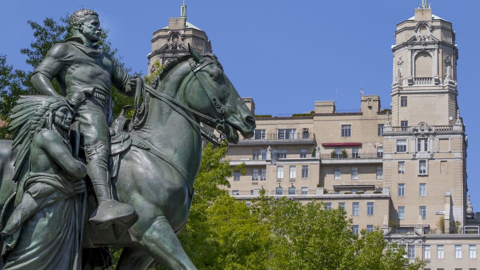A statue of a man on horseback with a building in the background.