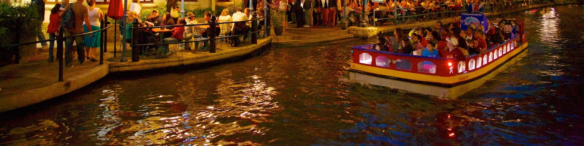 Downtown San Antonio which includes cafe lifestyle, night scenes and boating