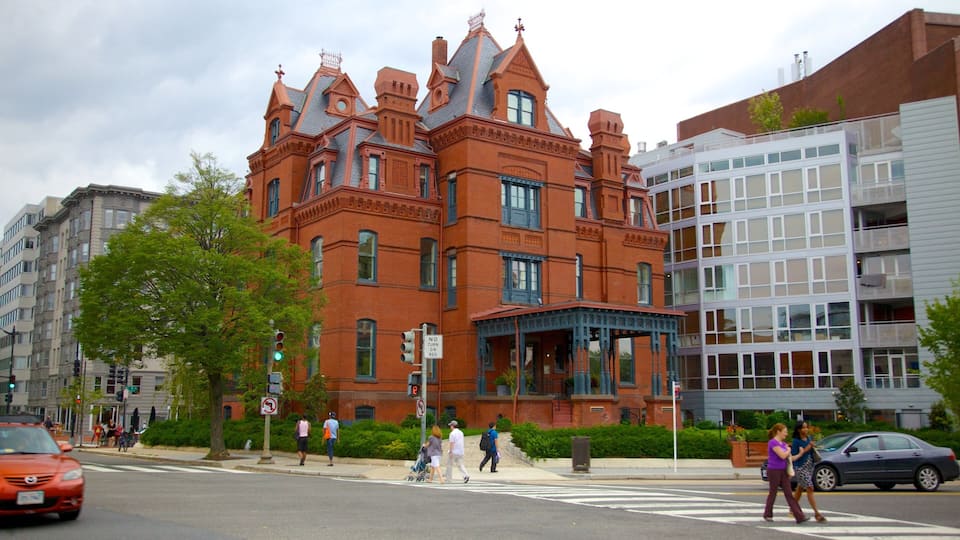 A historic red brick building with ornate detailing and a large bay window.