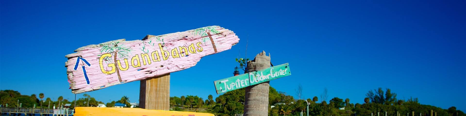 A wooden signpost with directional signs for Guanabans, Dock, Jupiter, and Dubois.