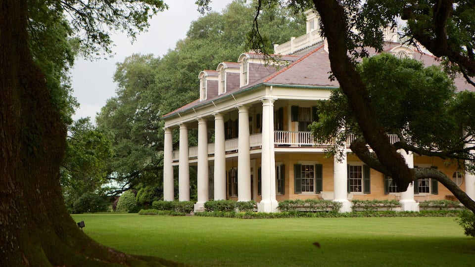 A large, colonial-style building with a symmetrical facade, columns, and a balcony.