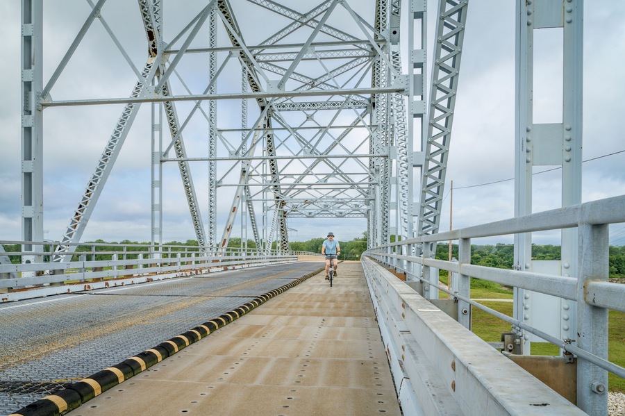 senior man is riding a folding bike over Chain of Rocks Canal Bridge near Granite CIty, Illinois