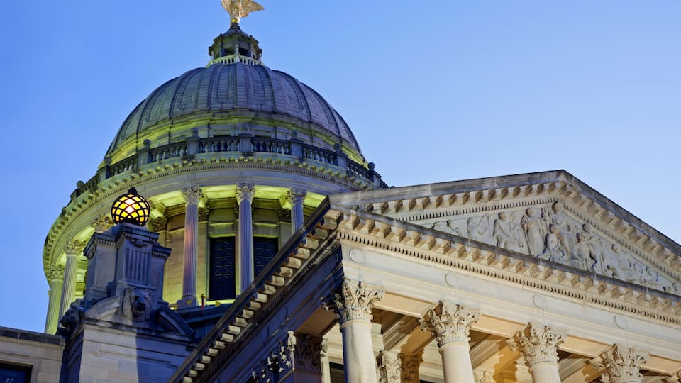 A grand building with a large dome, columns, and a staircase leading to the entrance.