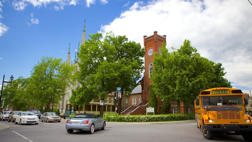 A church with a tall steeple, a brick building, and a yellow school bus.