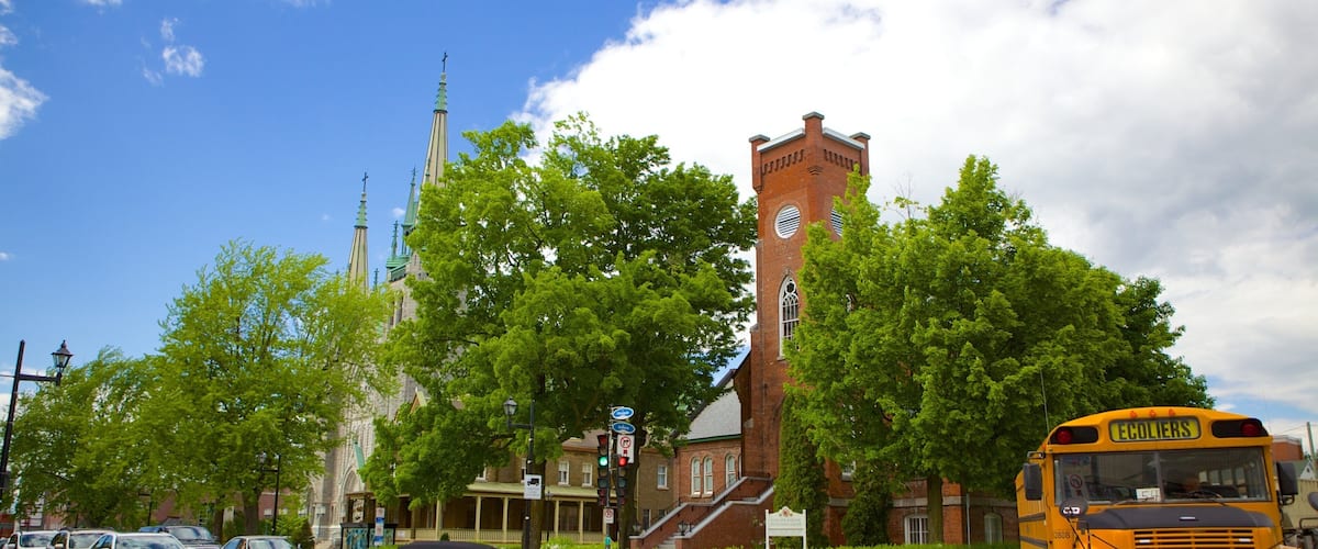 A church with a tall steeple, a brick building, and a yellow school bus.