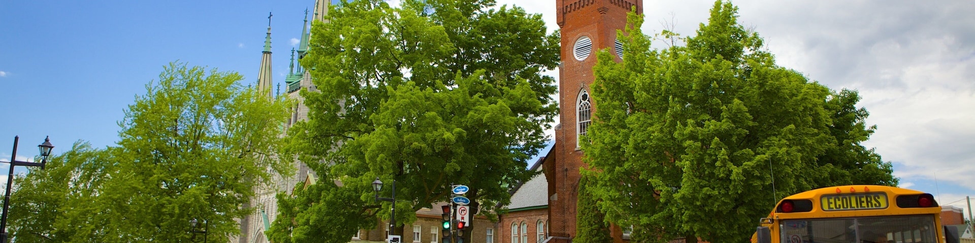 A church with a tall steeple, a brick building, and a yellow school bus.