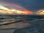 Una spiaggia con onde al tramonto.
