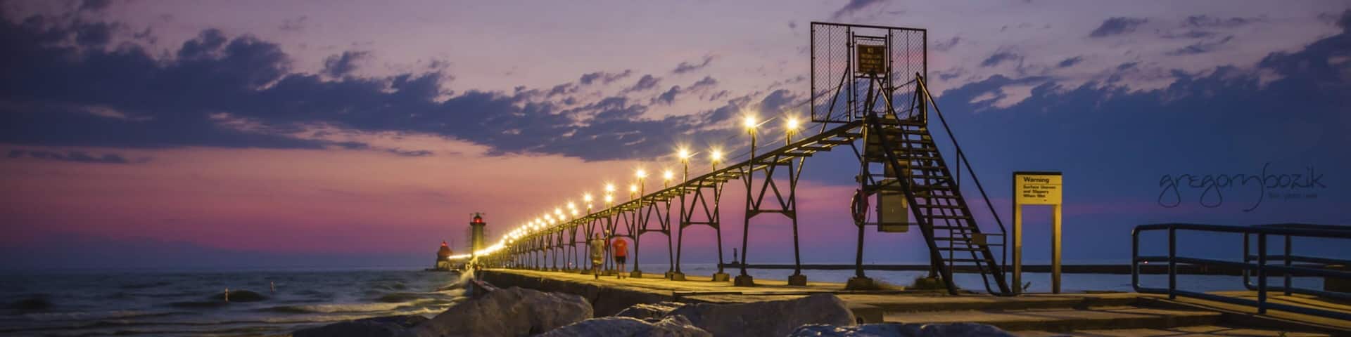 Grand Haven which includes a sunset and rocky coastline