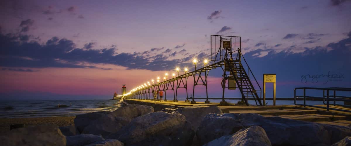 Grand Haven which includes a sunset and rocky coastline