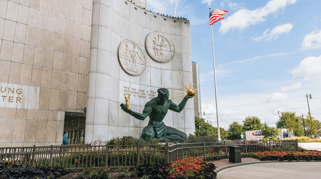 A statue of a figure holding a torch, a building with inscriptions, and an American flag.