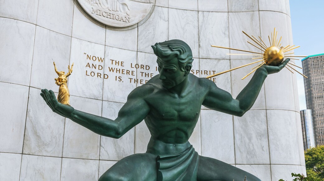 A statue of a muscular man holding a torch, with a plaque behind him that reads 'Now the Lord is Spirit, and where He is, there is Peace.'