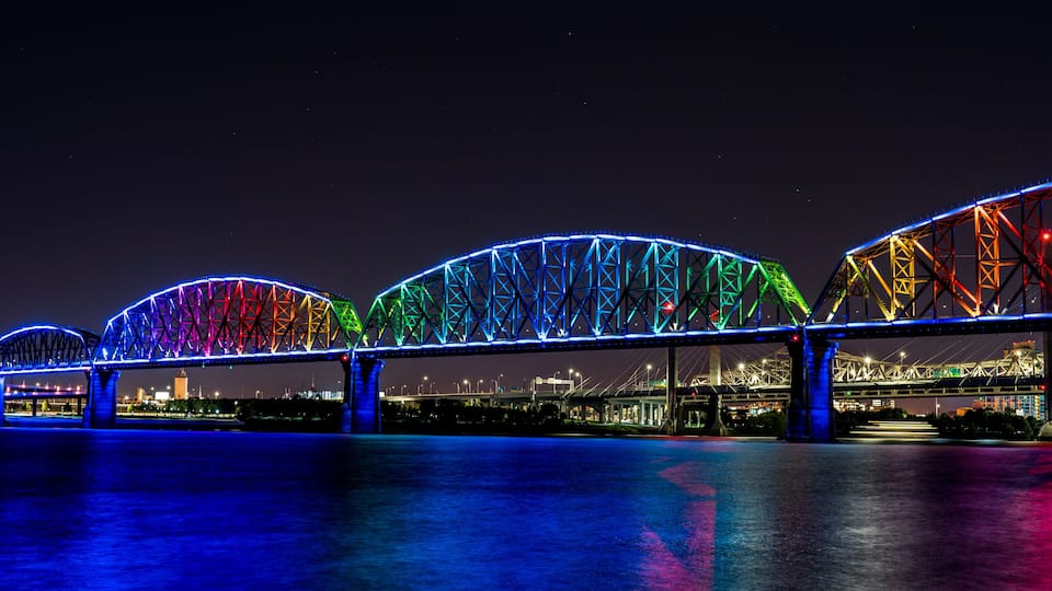 A brightly lit bridge with multiple arches at night.