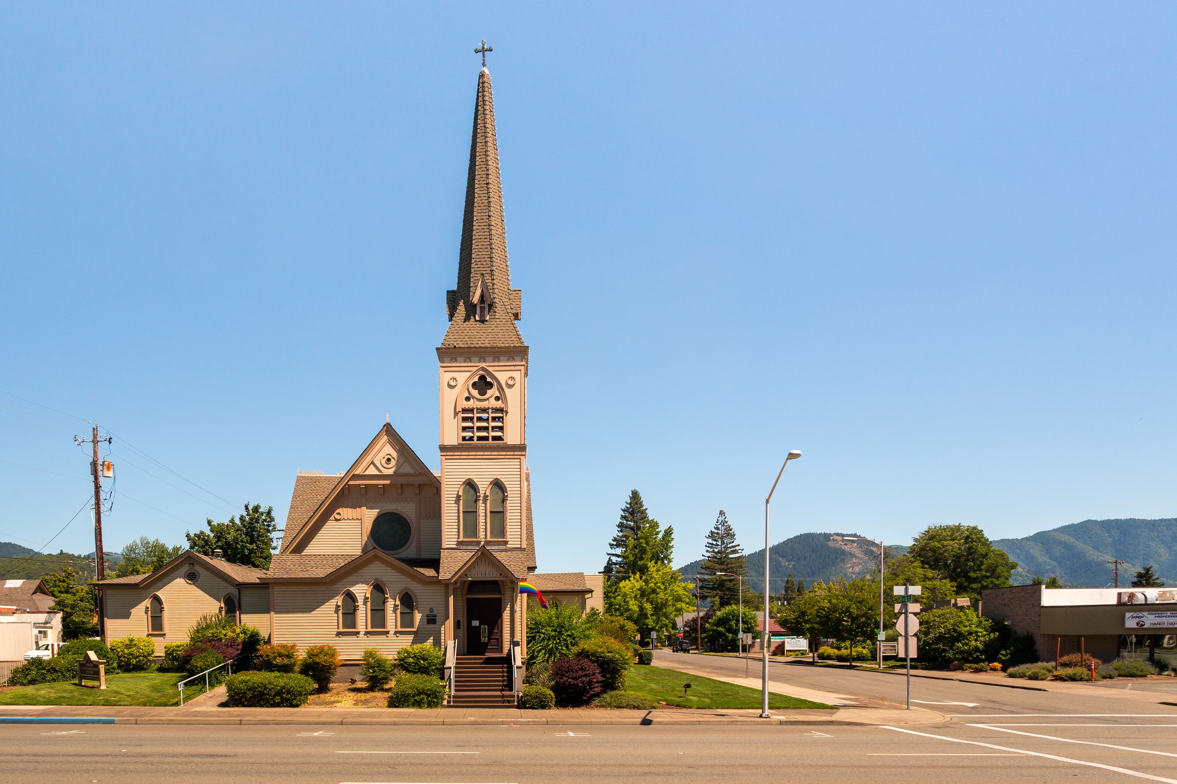 Newman United Methodist Church in downtown Grants Pass. The evolving rainbow flag above the entrance shows loyalty to the LGBTQ movement