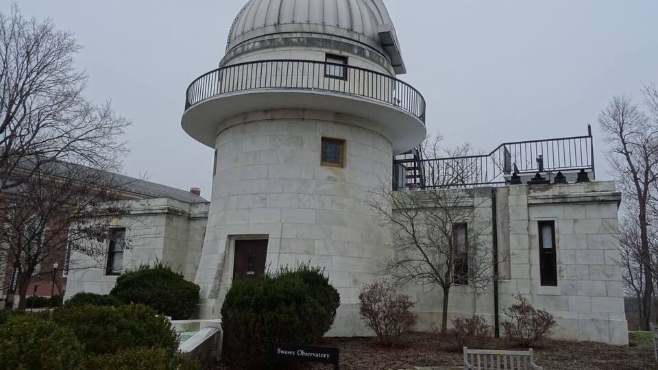 A white observatory with a dome and a balcony.