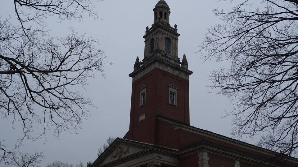 A large brick building with a prominent tower and columns.
