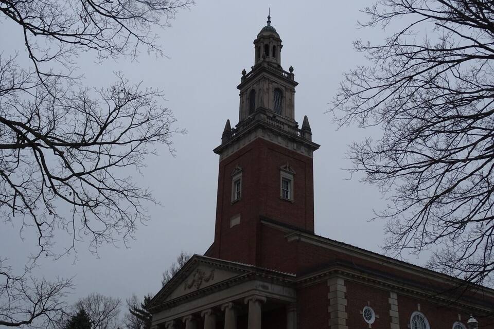 A large brick building with a prominent tower and columns.