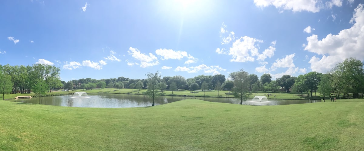 Large neighborhood park double water fountains pond near Dallas, Texas, USA cloud sky