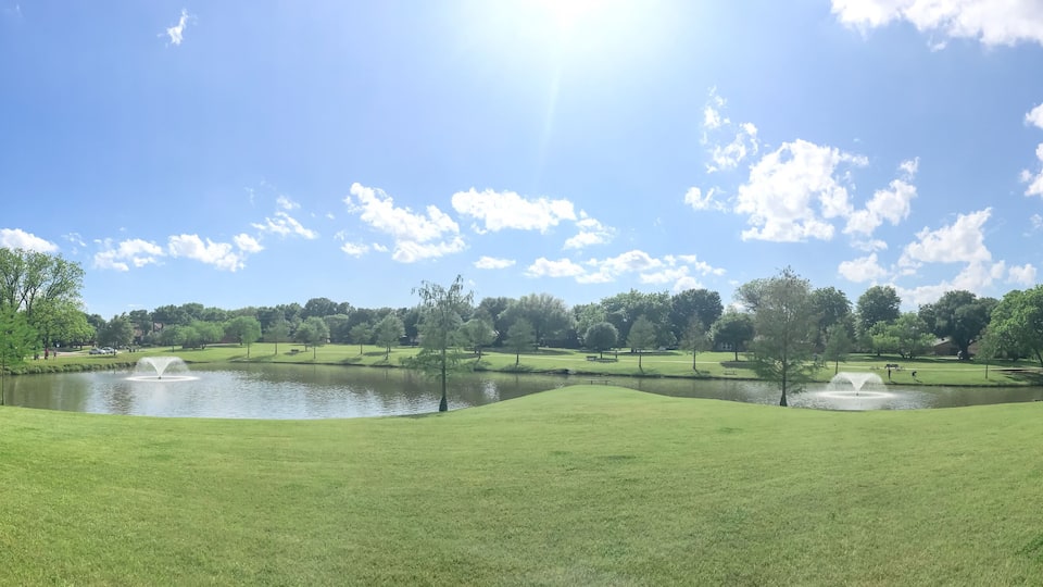 Large neighborhood park double water fountains pond near Dallas, Texas, USA cloud sky