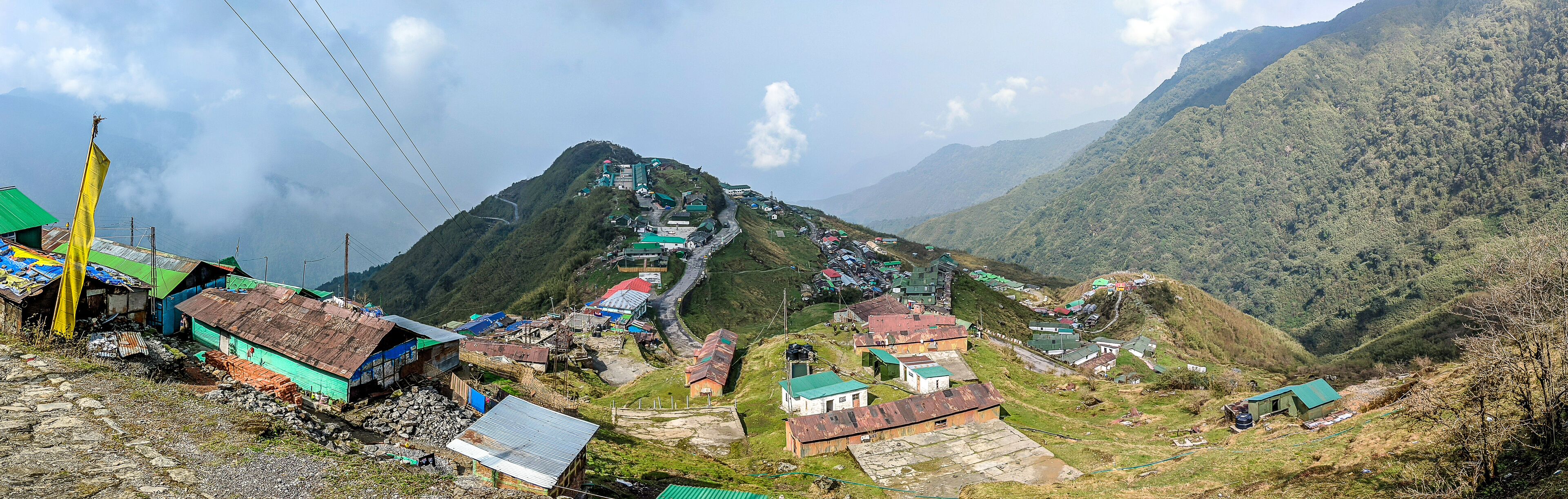 A mountainous village with houses and a winding road.