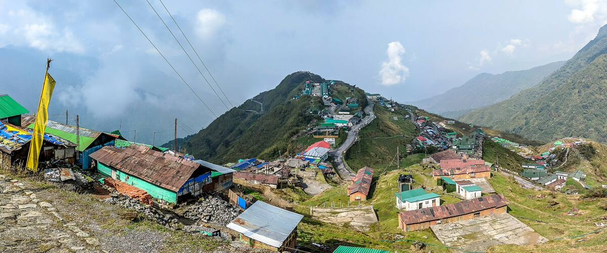 A mountainous village with houses and a winding road.