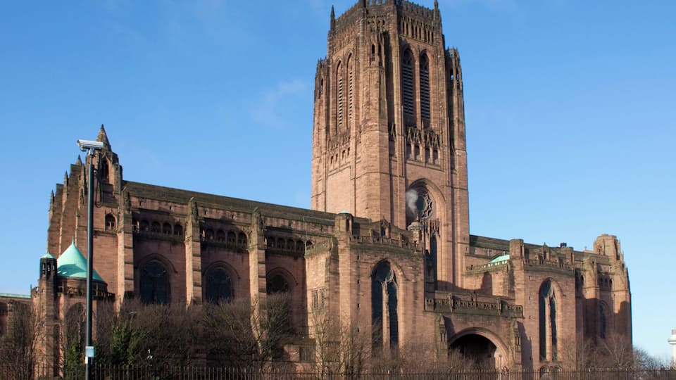 A large historic cathedral with a tall central tower and multiple arches.