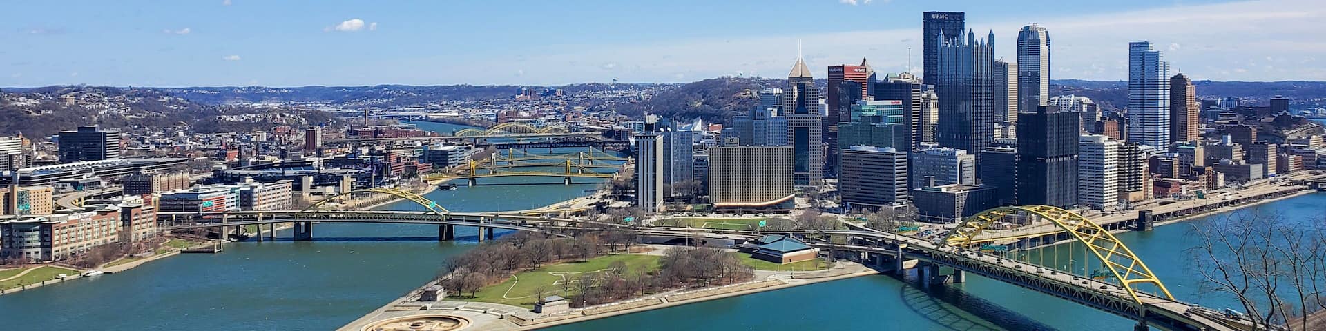 Pittsburgh, Pennsylvania, USA – April 10, 2024: Panoramic view of Point State Park where the Allegheny and Monongahela Rivers meet to form the Ohio River, with Acrisure Stadium and downtown in view.